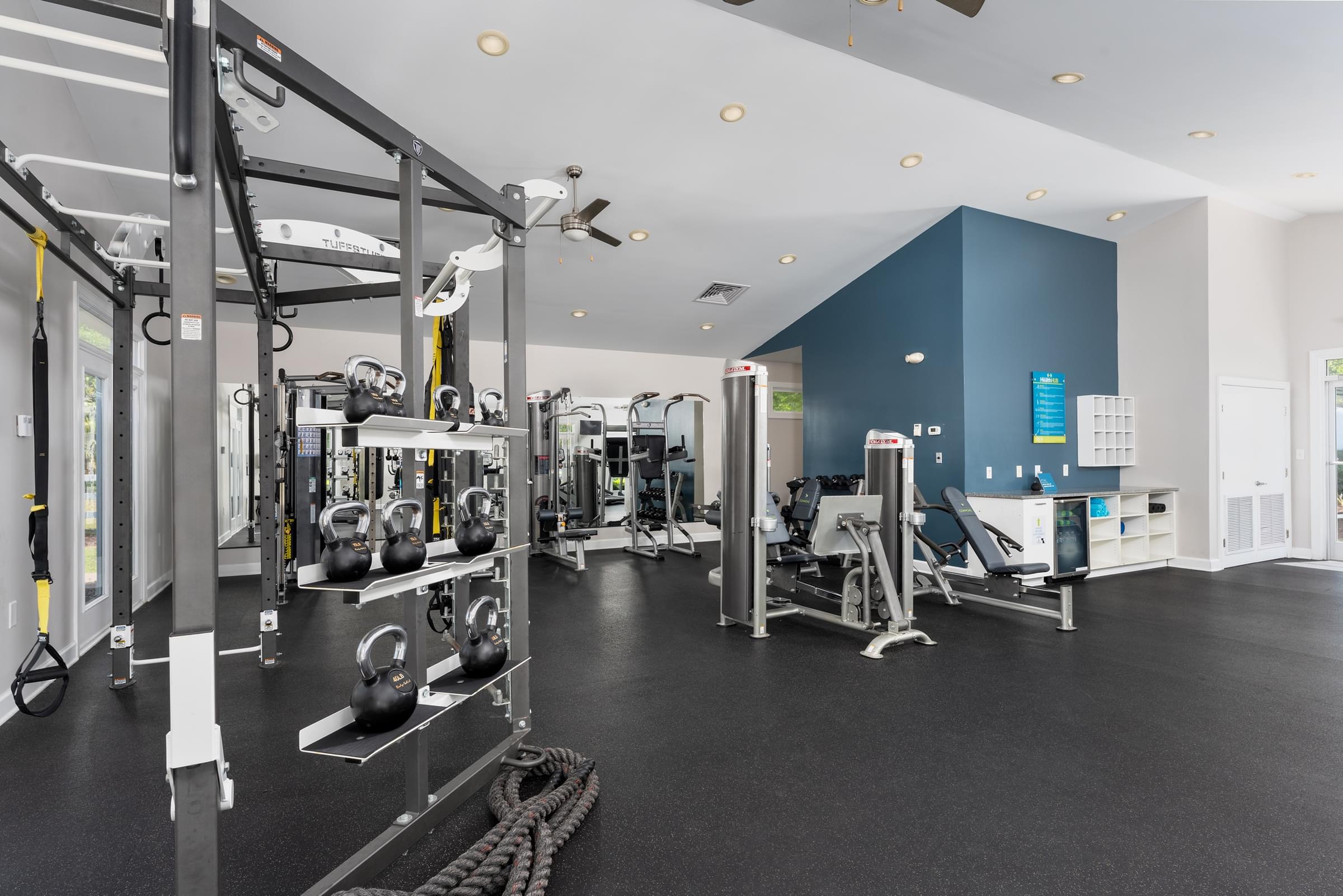 A gym with a variety of equipment including weights and a rowing machine.