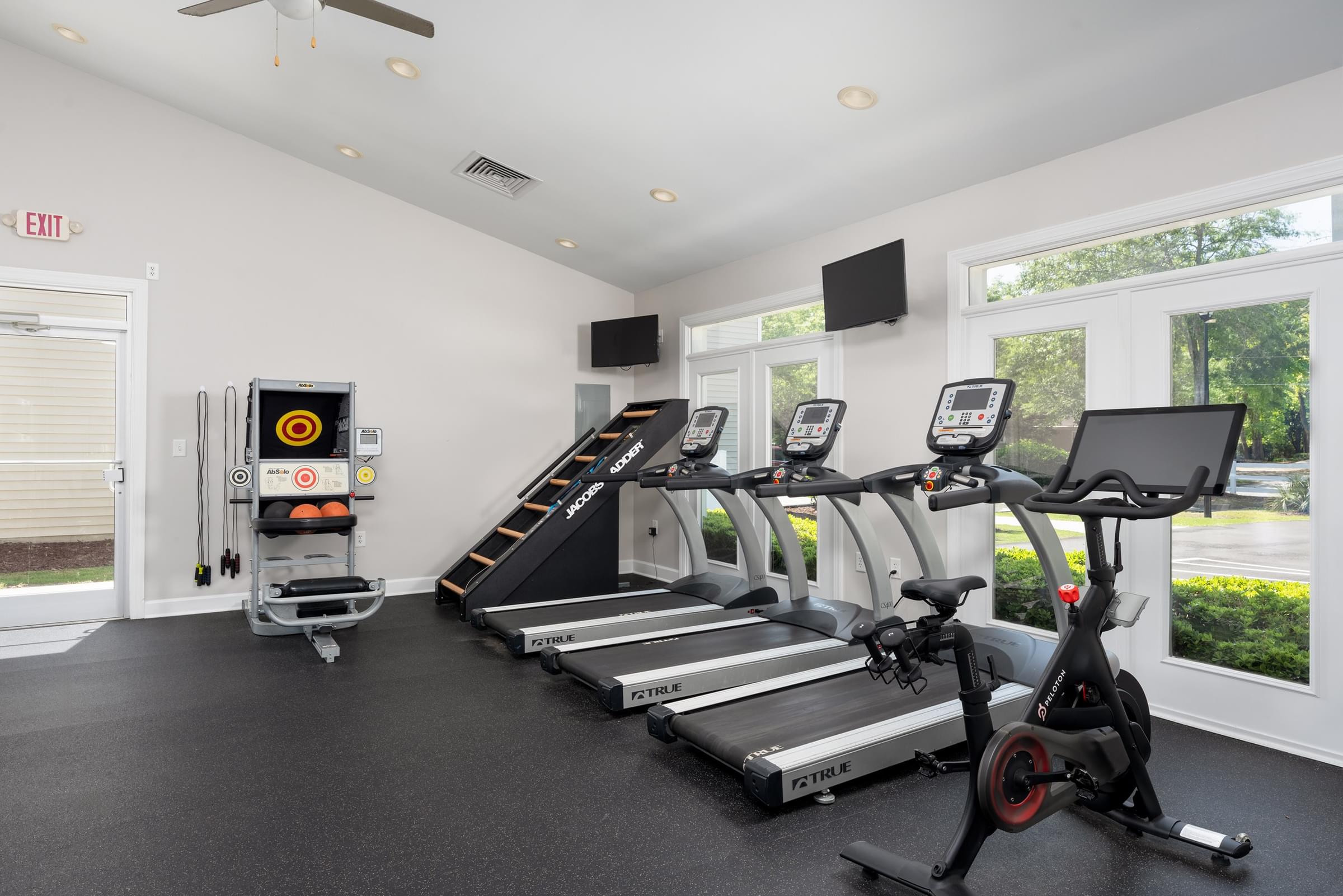 A gym with treadmills, exercise bikes, and a weight machine.