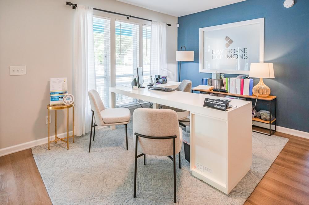 a home office with a blue accent wall and a white desk with two chairs