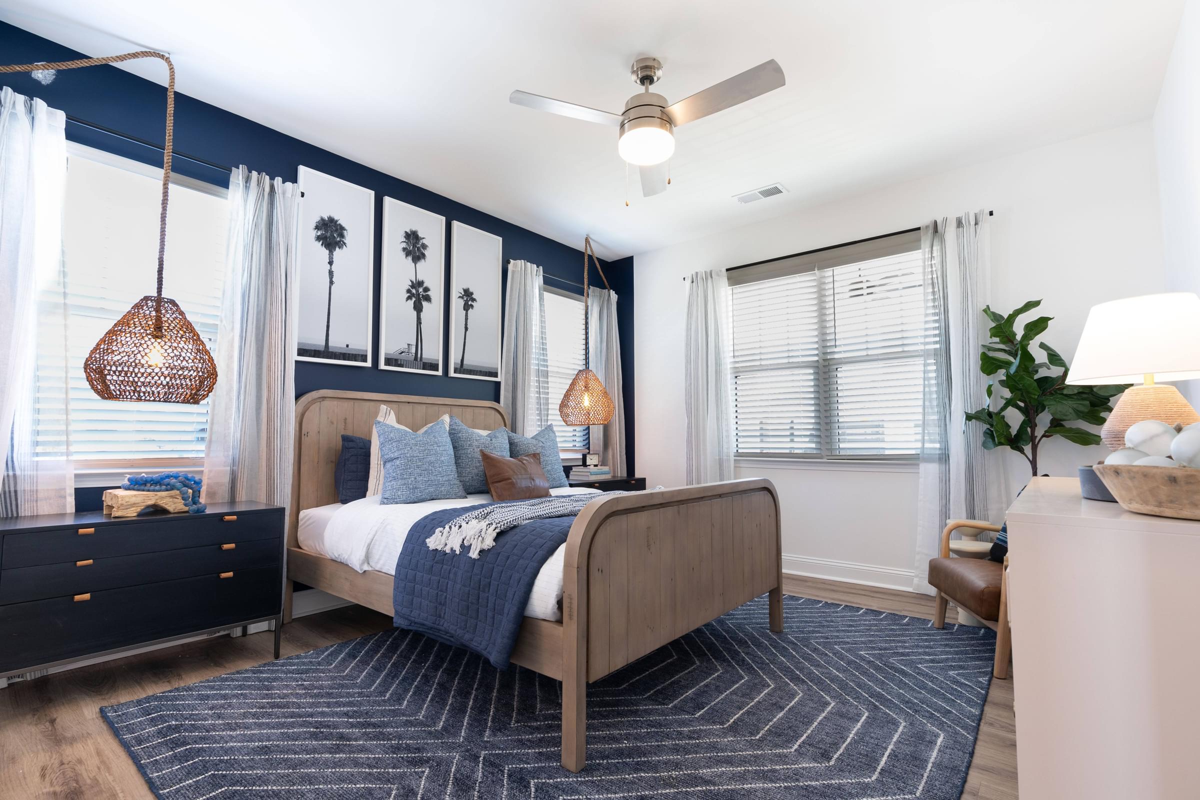 A bedroom with a bed, nightstand, and a ceiling fan.