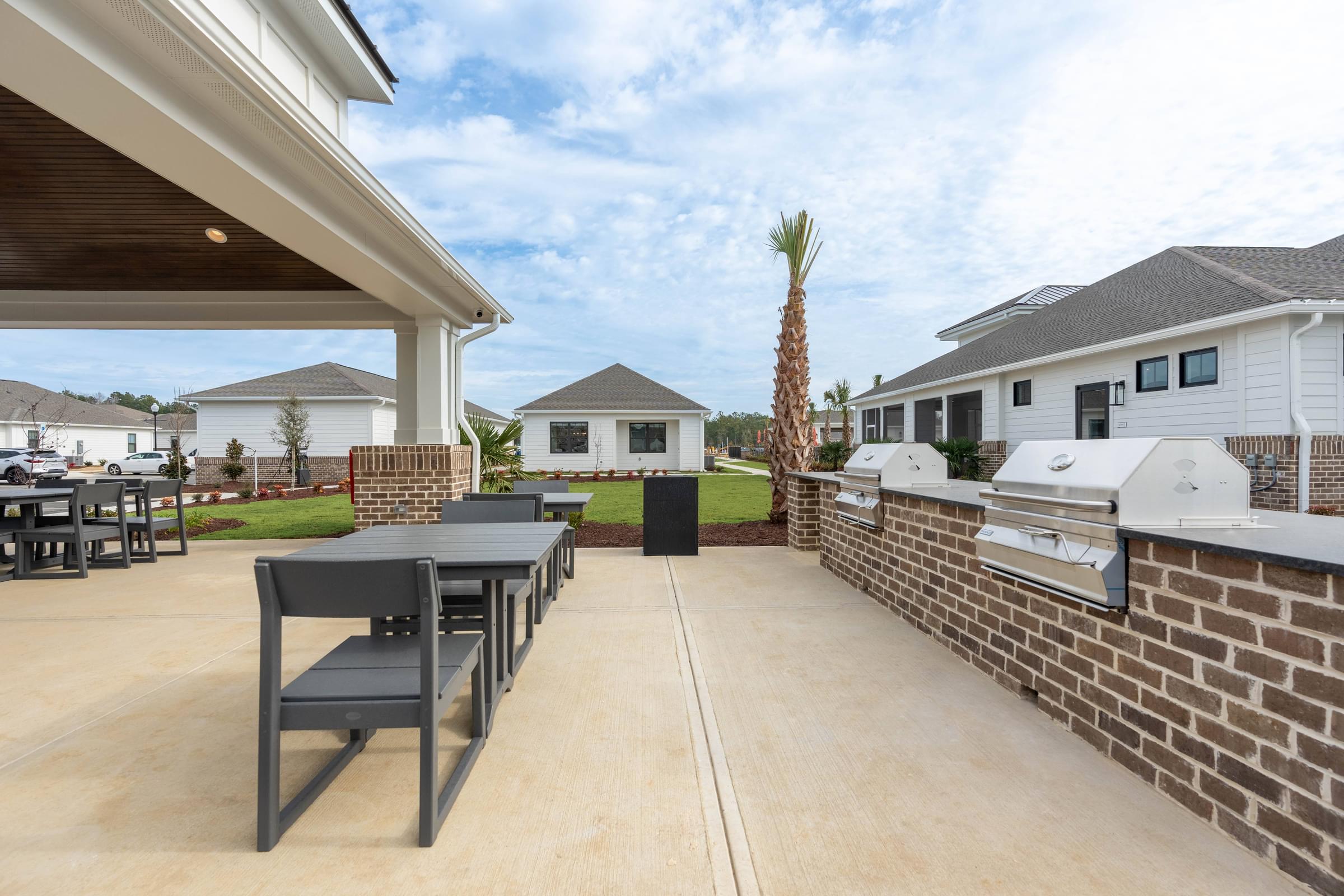 A patio with a table and chairs is surrounded by houses.