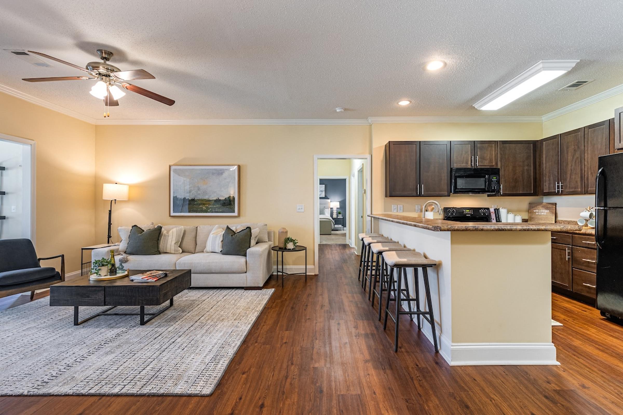 a living room with a couch and a kitchen with a bar