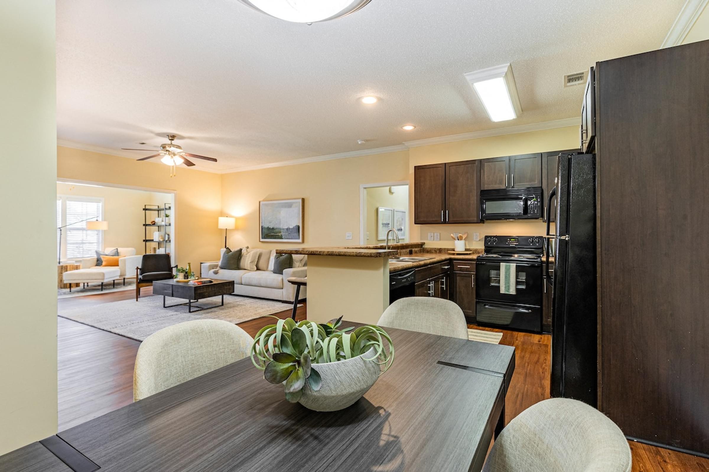 the view of a living room and kitchen with a table and chairs