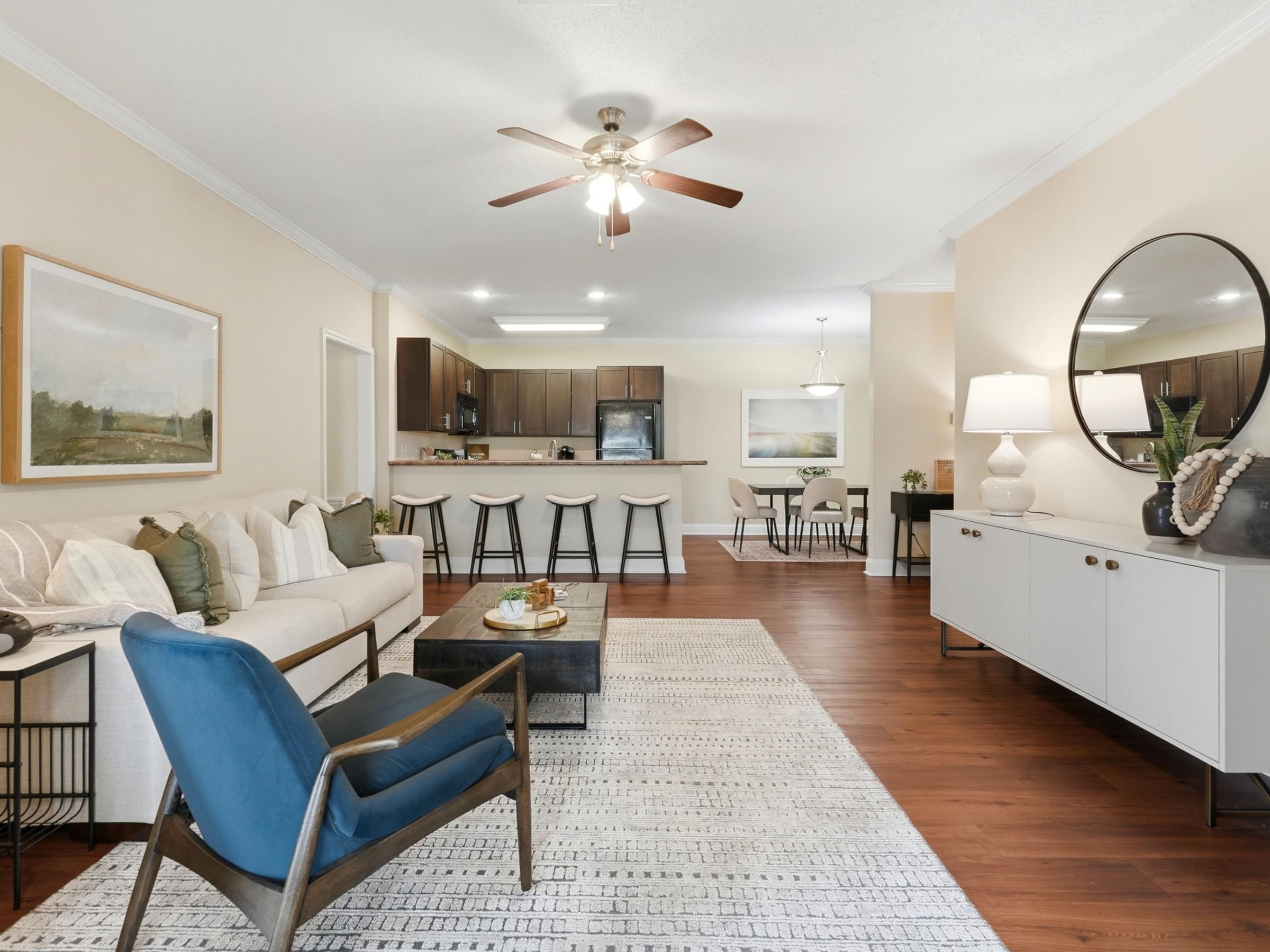 A living room with a blue chair and a white couch.