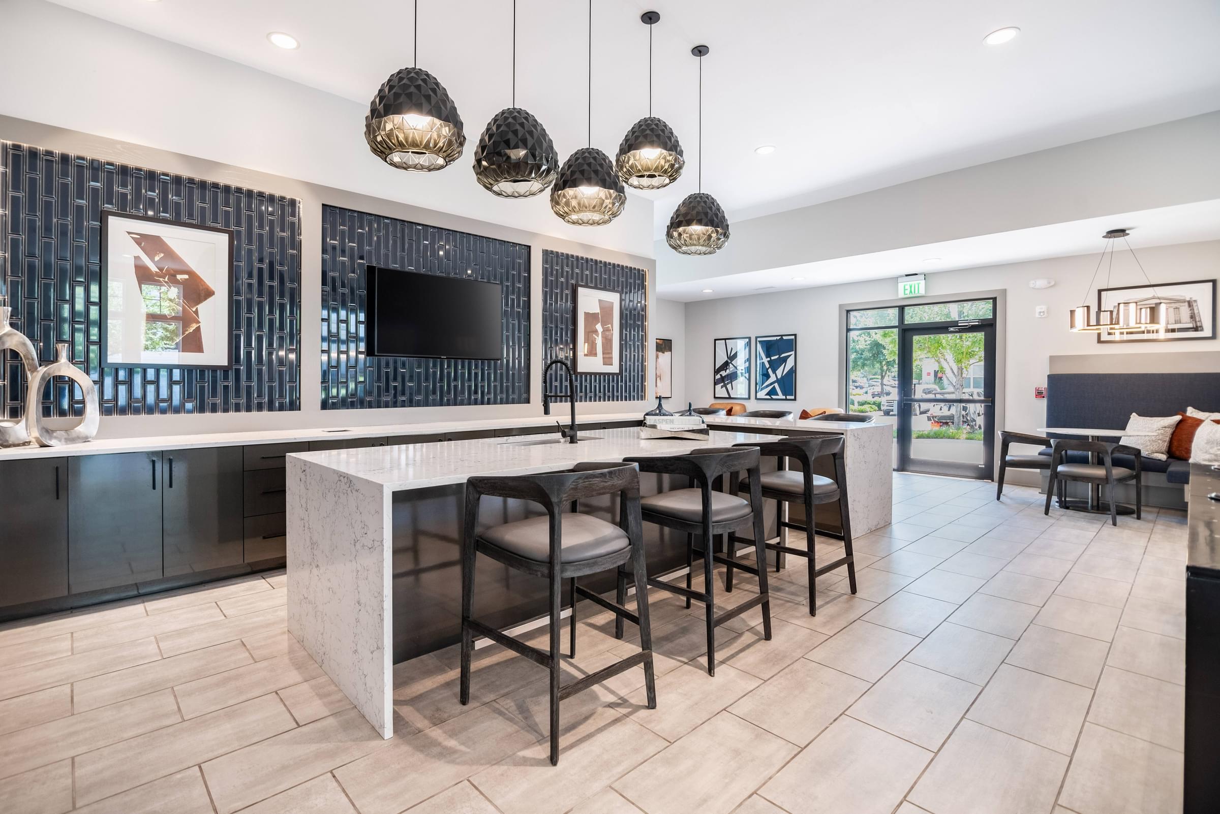 a kitchen with a large island with stools and a dining room with chairs