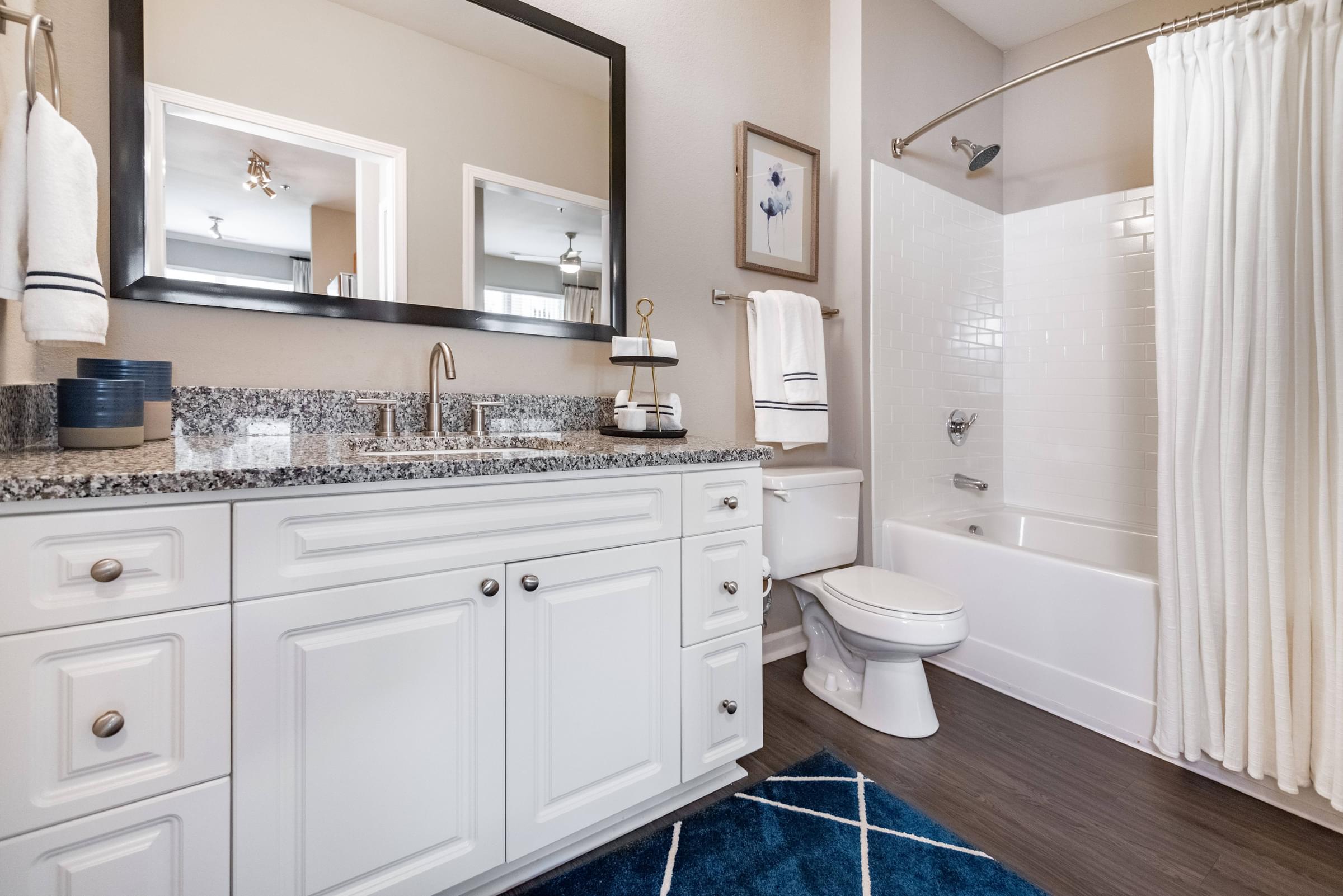 Bathroom with Luxury Vinyl Plank Flooring, Granite Countertops, and Deep-Soaking Garden Bathtub