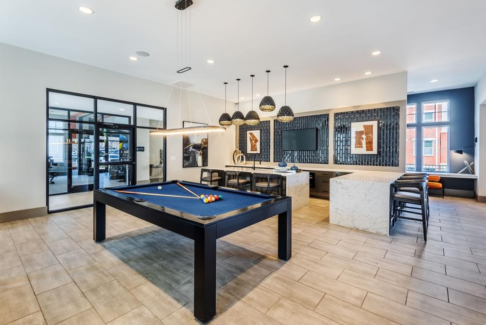 a clubhouse with a pool table and a kitchen with a bar