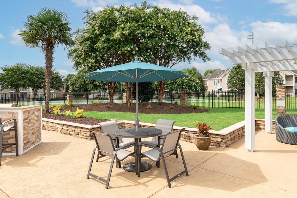 a patio with a table and chairs under an umbrella