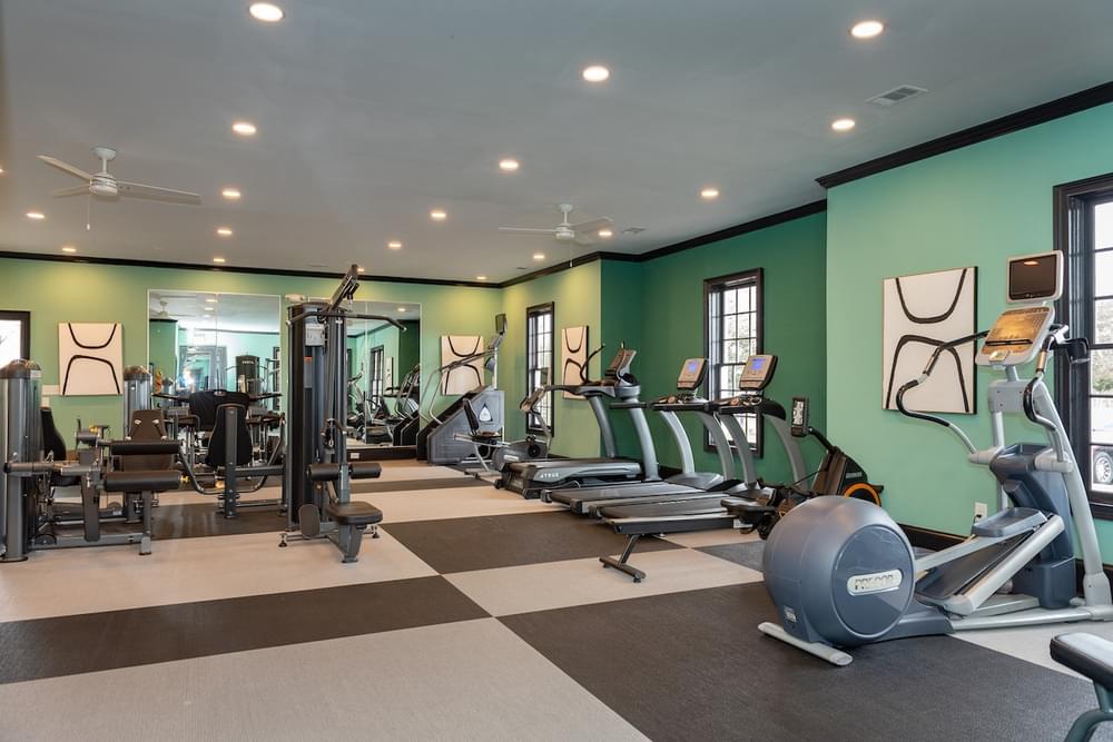 a gym with cardio equipment and weights on a checkered floor