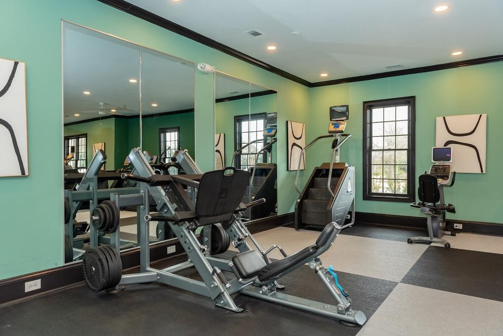 a gym with weights and mirrors in a home gym