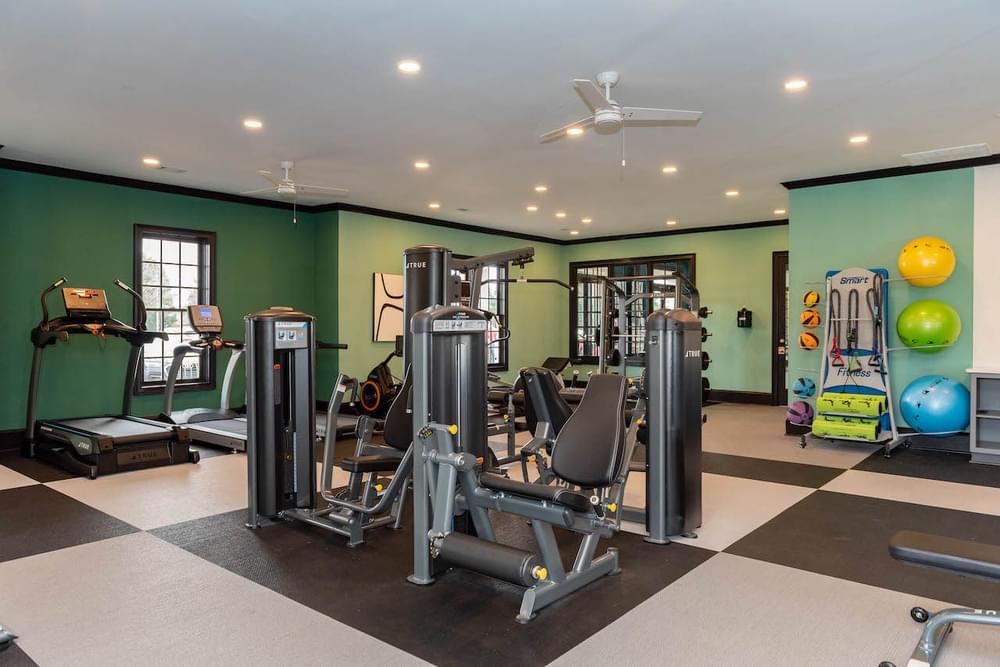 a gym with weights and other equipment in a home with green walls