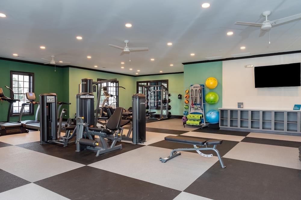 a gym with exercise equipment and a tv on the wall