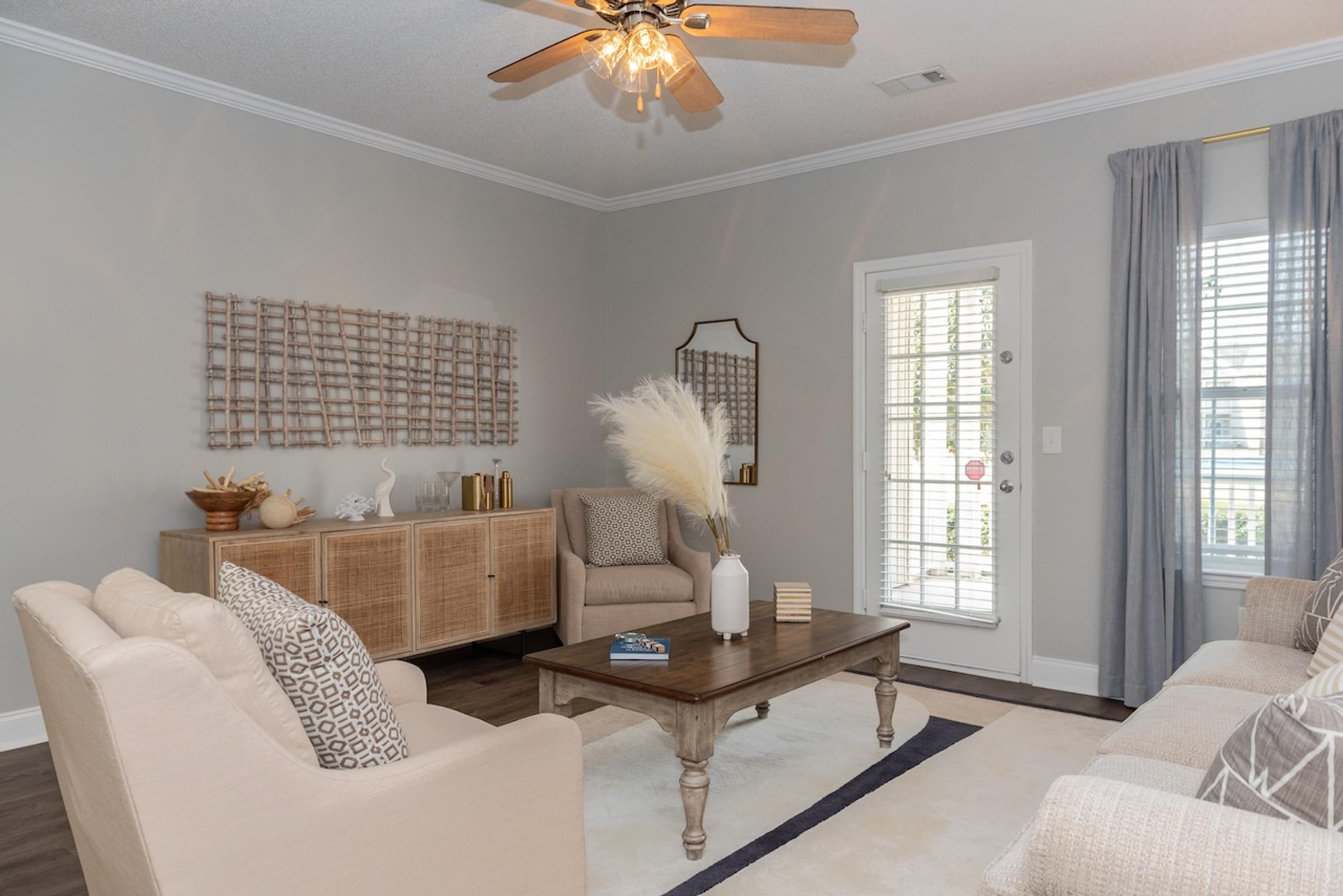 Open-Concept Living Room with Ceiling Fans and Large Windows