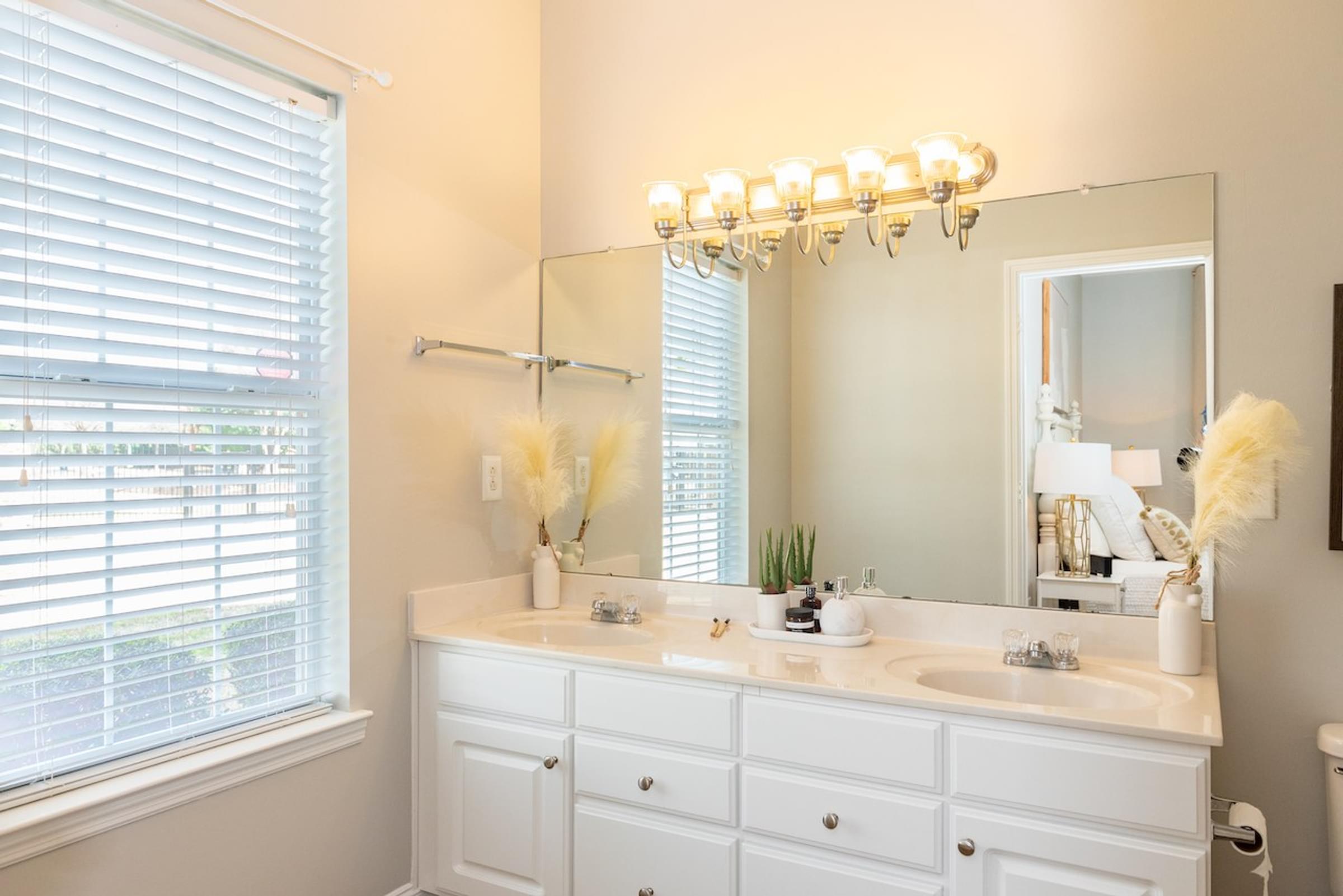 a bathroom with a sink and a mirror and a window