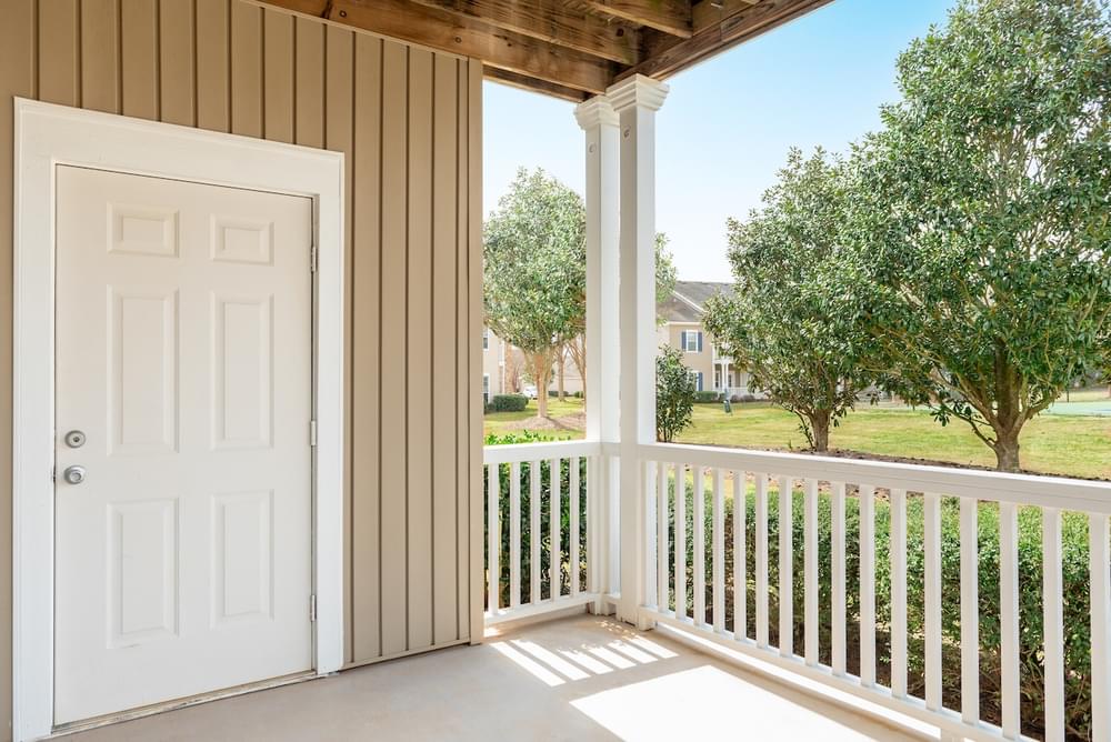 the view from the porch of a home with a white door