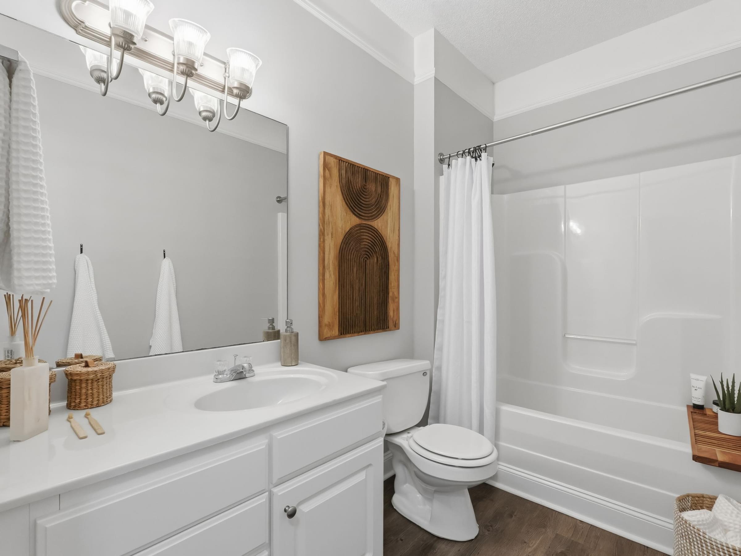 A white bathroom with a toilet, sink, and a mirror.