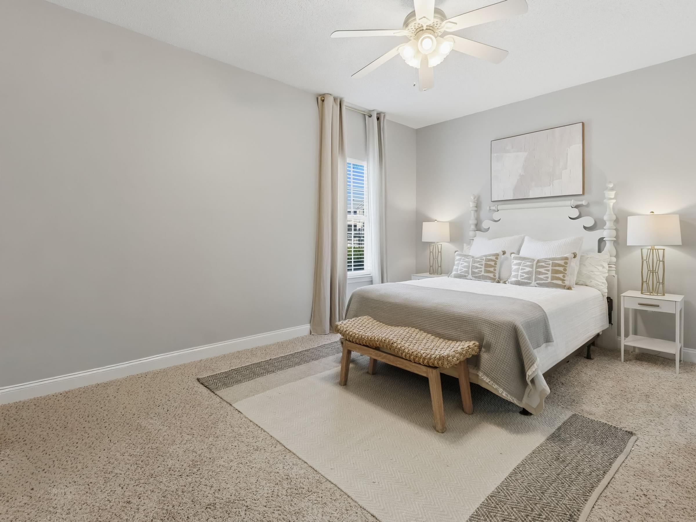 A bedroom with a bed, nightstand, and a ceiling fan.