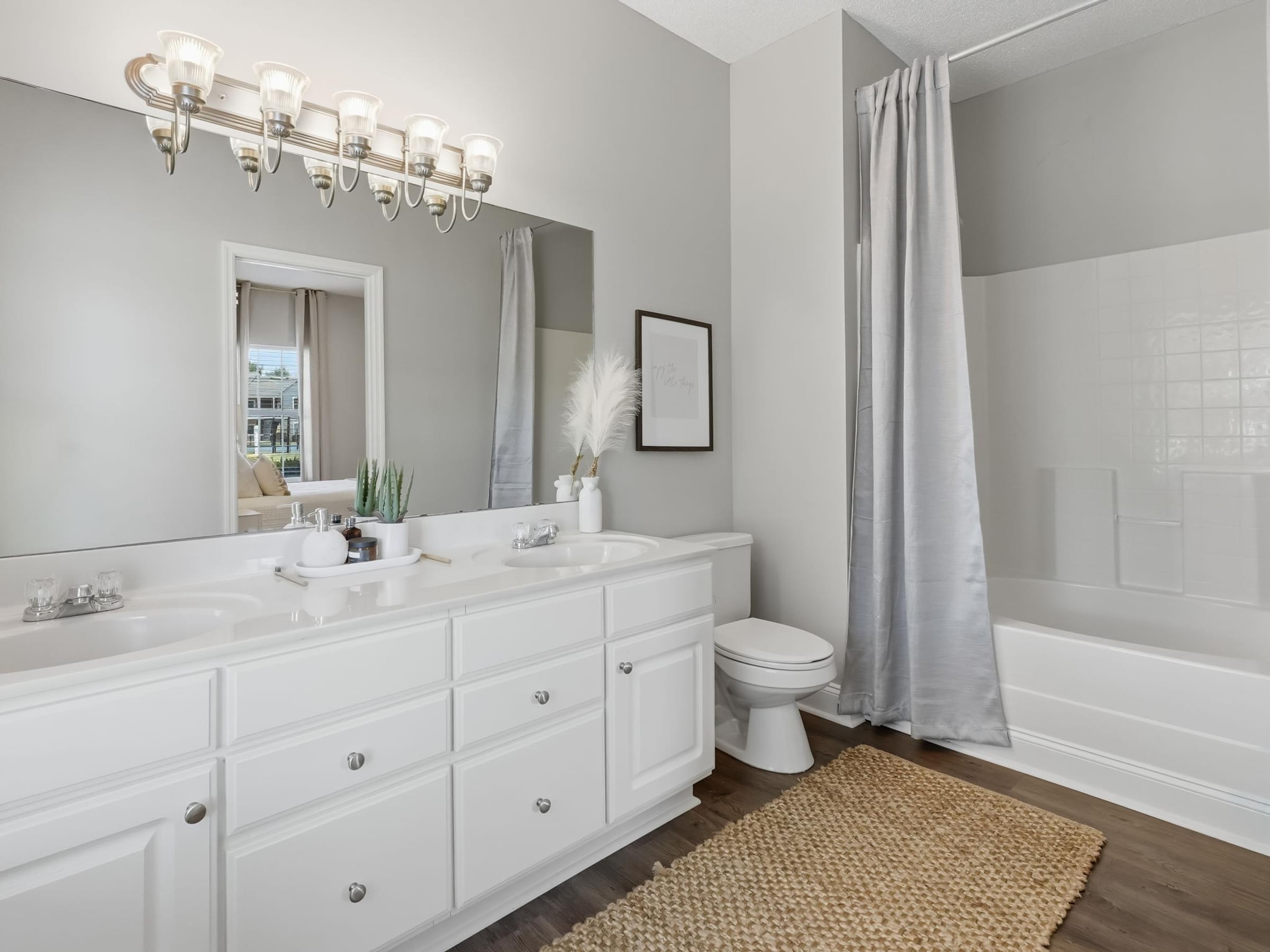 A white bathroom with a toilet, sink, and shower.