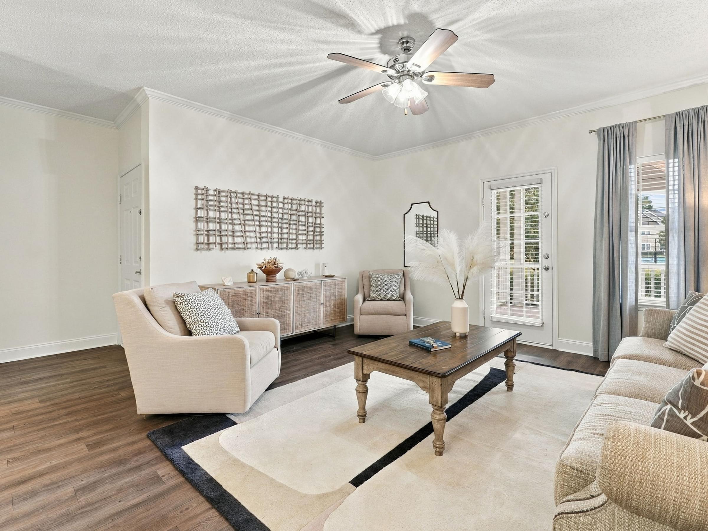 A living room with a white ceiling fan and a wooden coffee table.