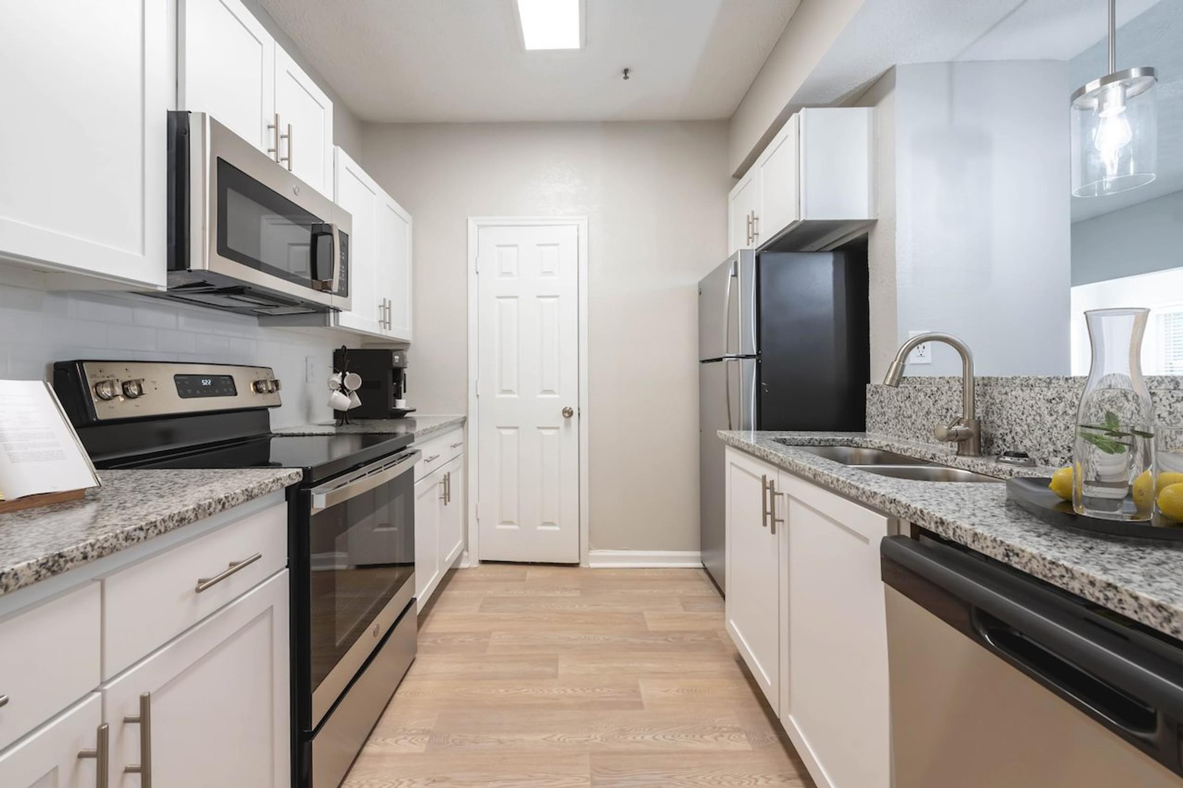 a kitchen with white cabinets and black appliances
