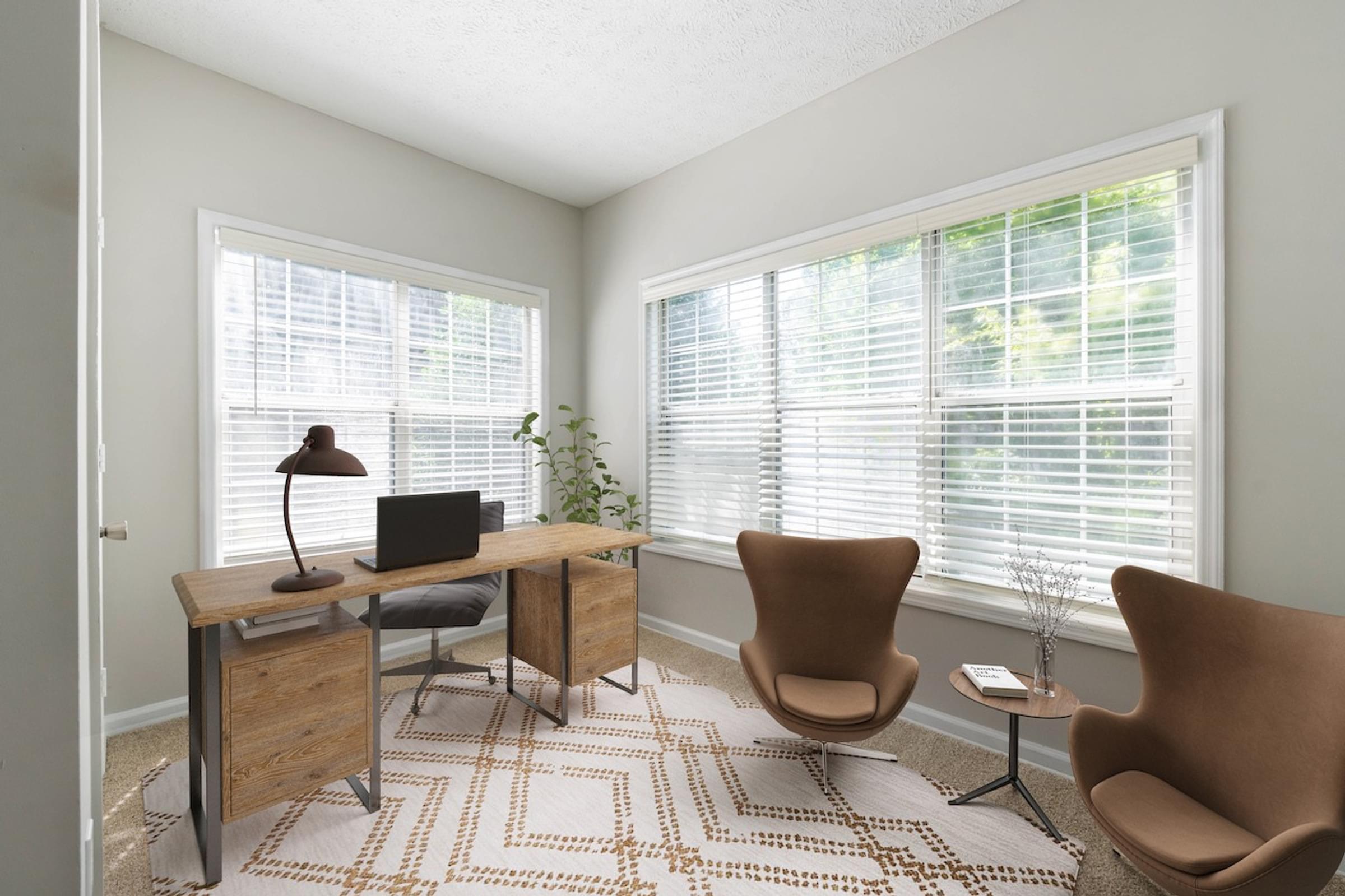 a home office with two chairs and a desk with a computer on it