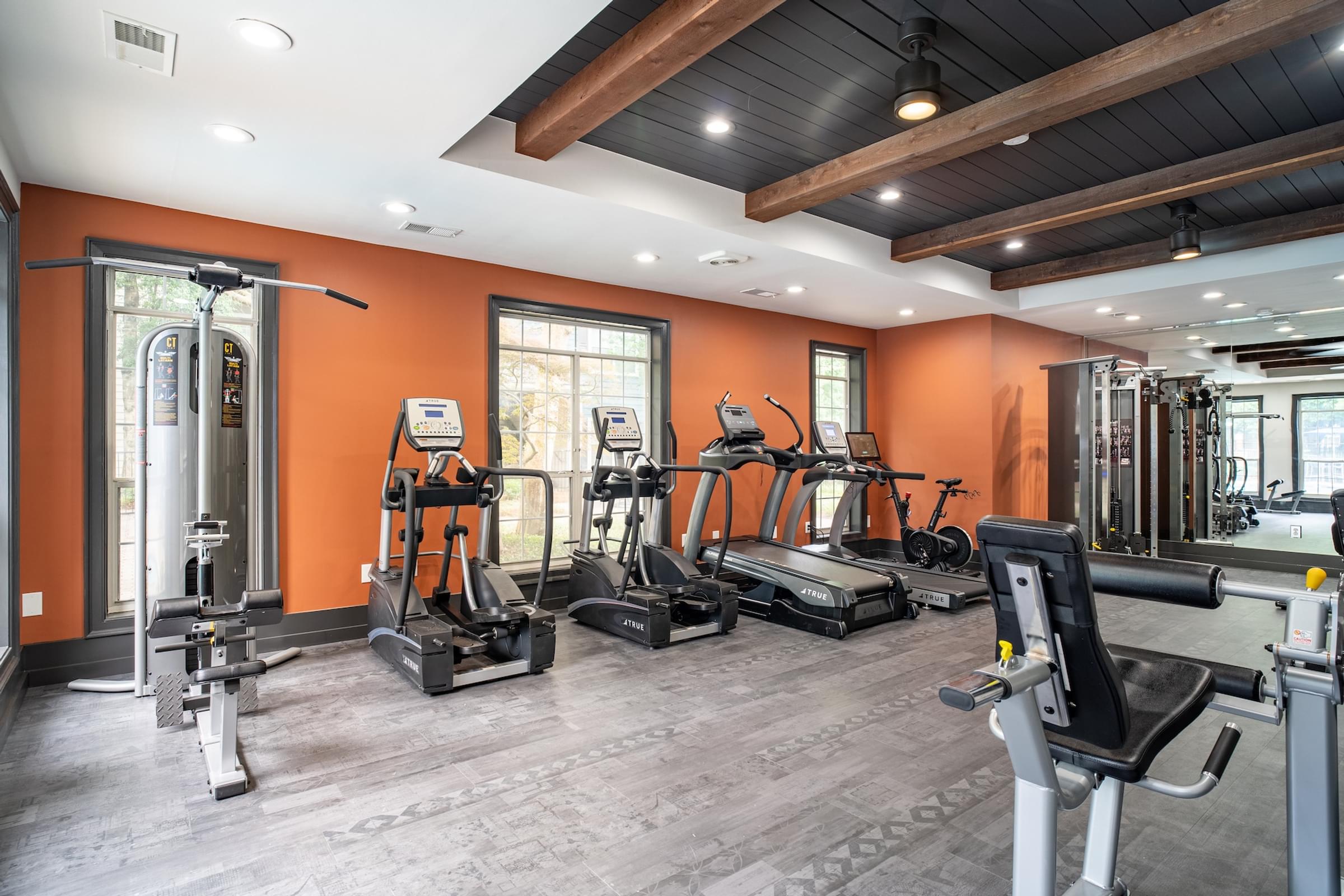 a gym with cardio equipment and weights on the floor
