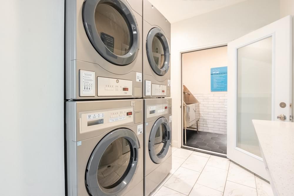 a washer and dryer in a laundry room with a door to a bathroom