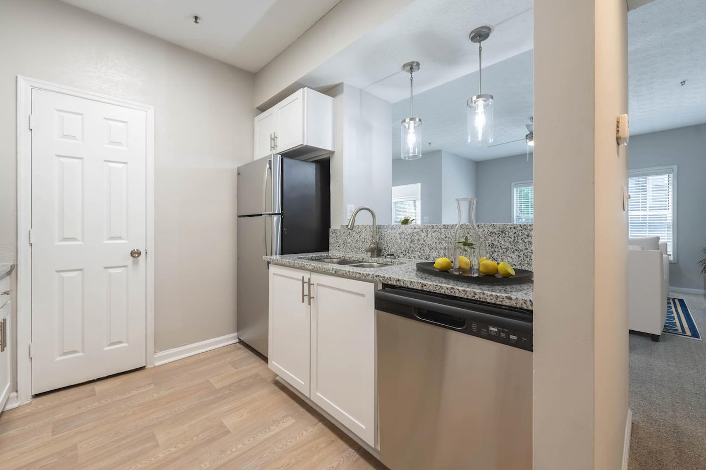 a kitchen with white cabinetry and granite countertops