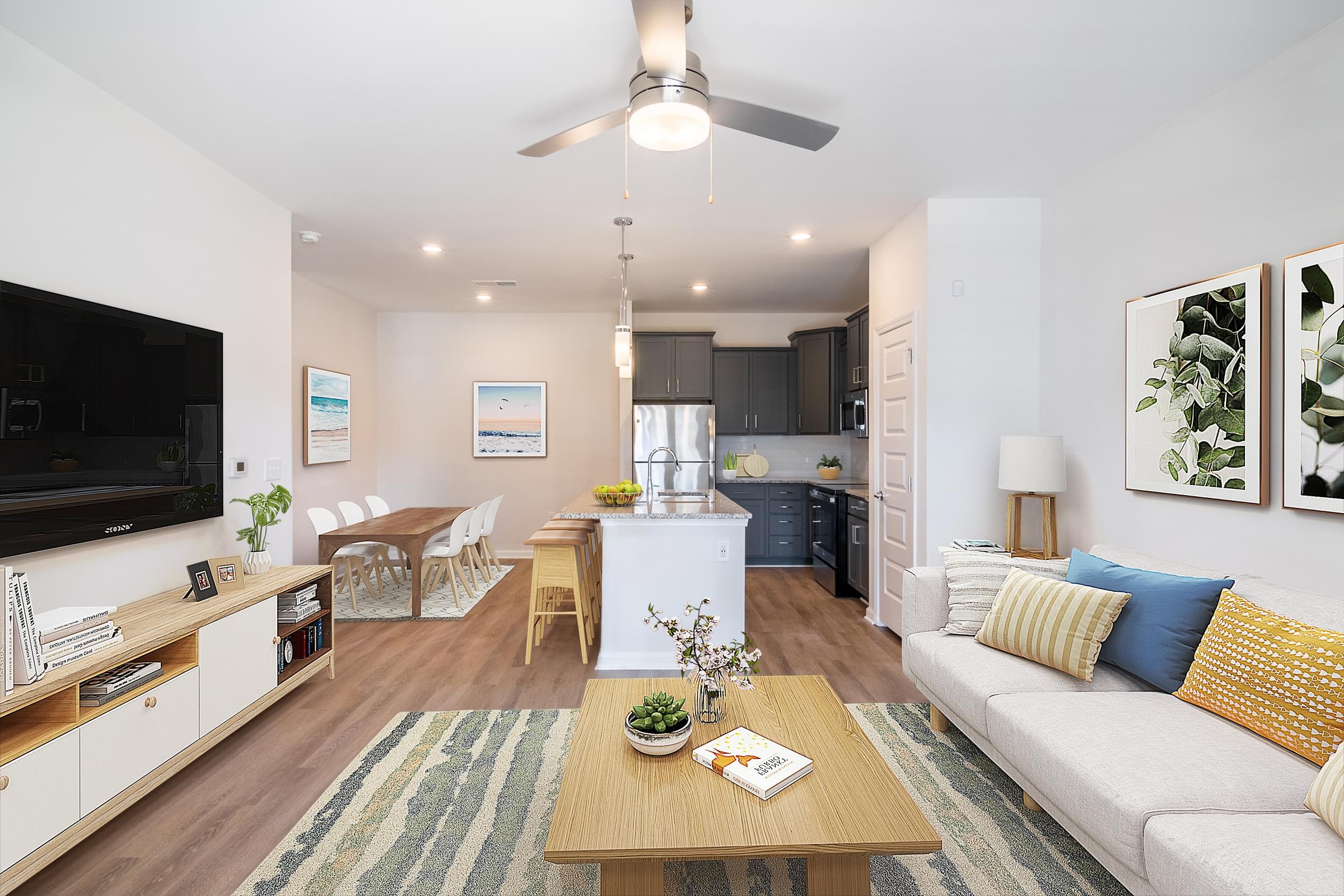 a living room and kitchen with white walls and wood floors