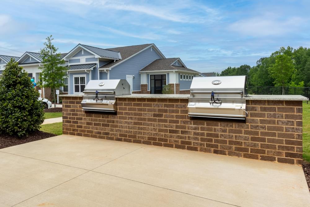 a brick retaining wall with two bbq grills on it