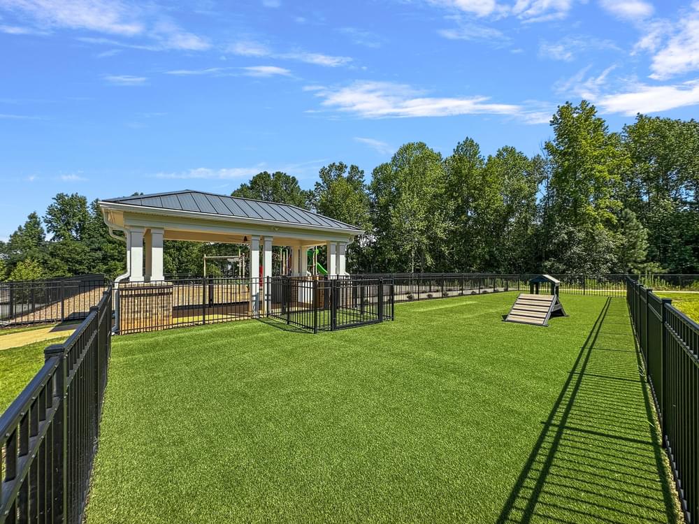 a gazebo in a park with a lawn and fence