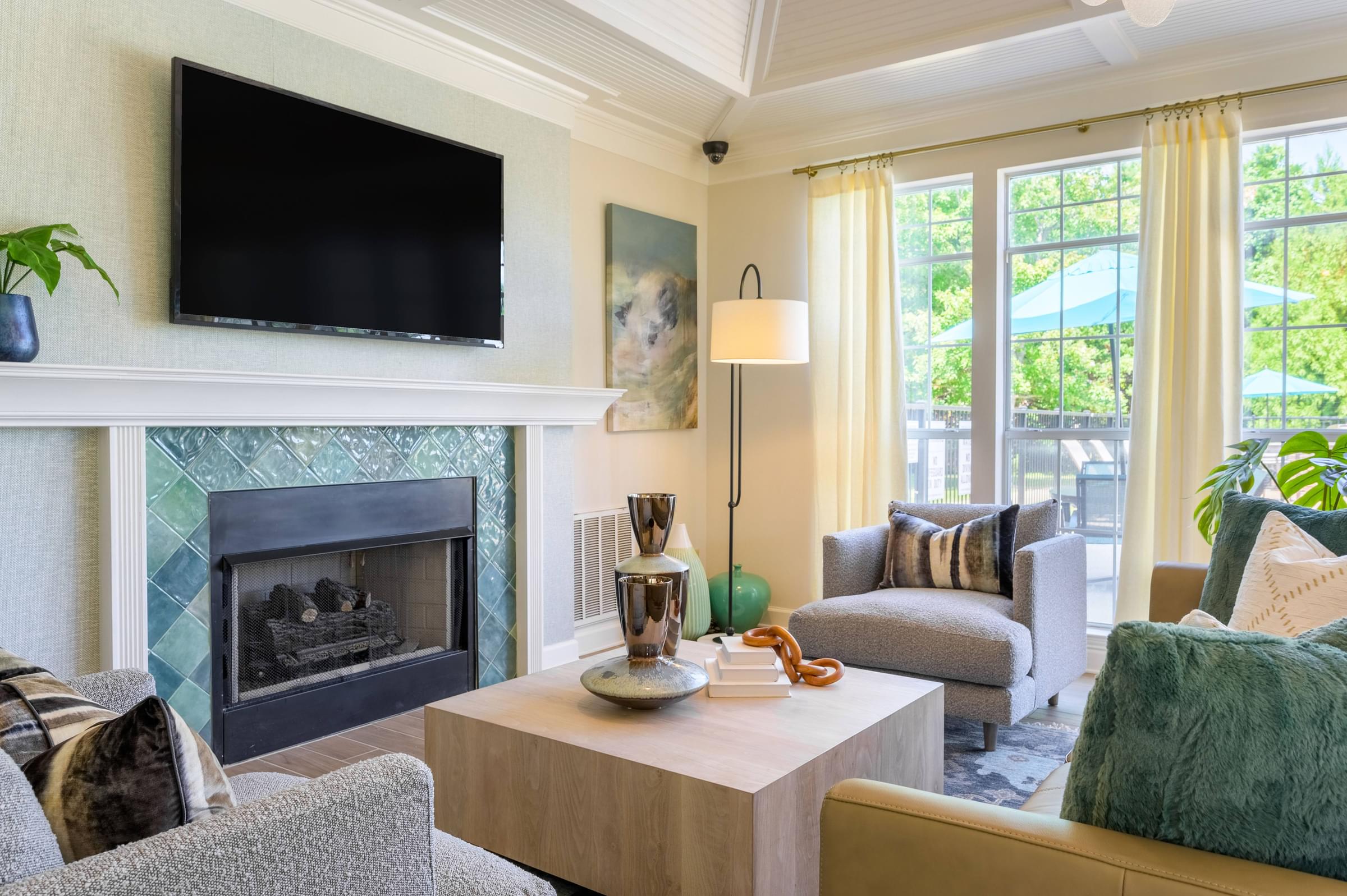 A living room with a fireplace and a flat screen TV mounted above it.