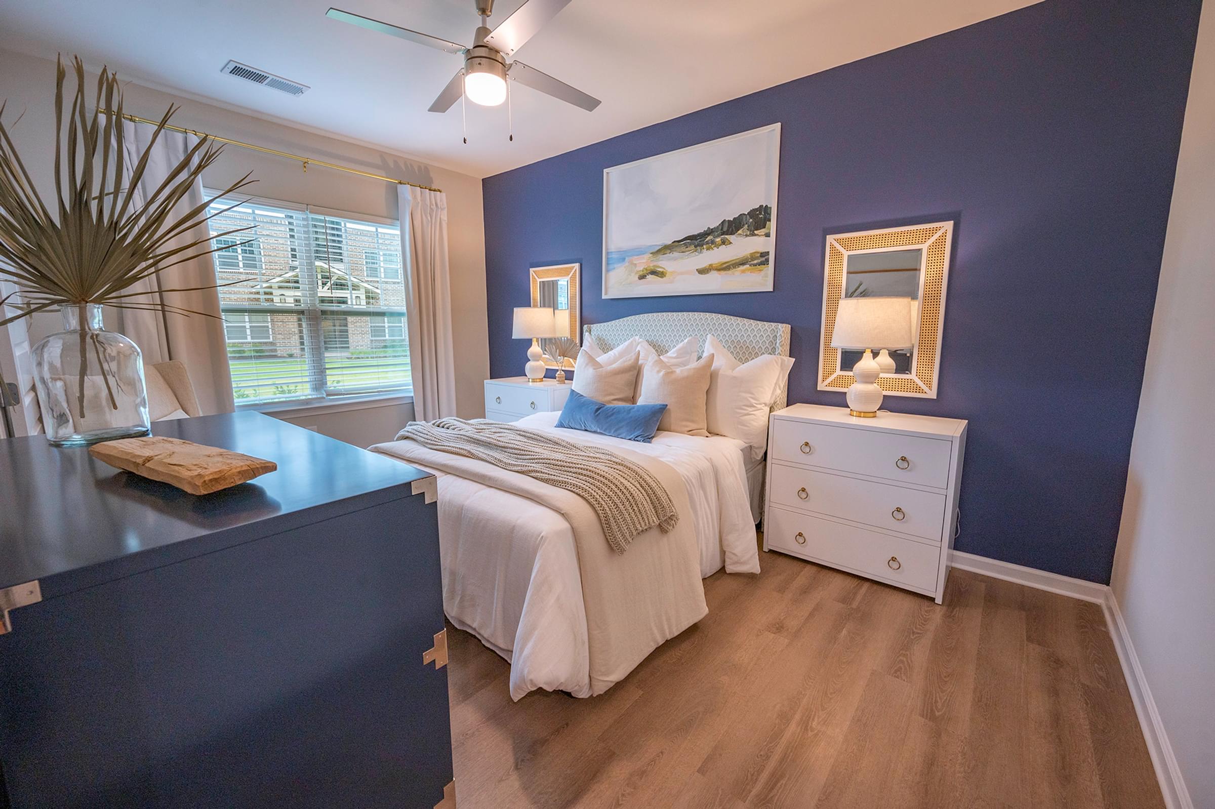 a blue and white bedroom with a bed and a window