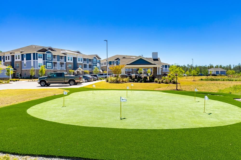 a putting green with houses in the background