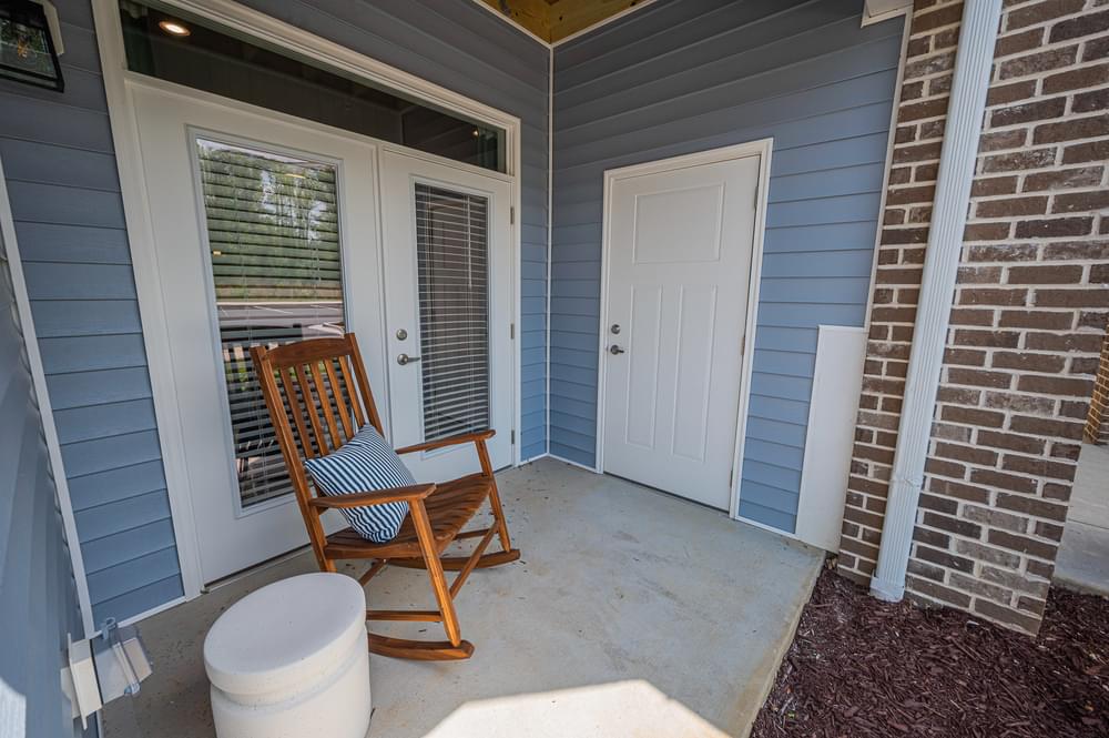 a front porch with a rocking chair and a door