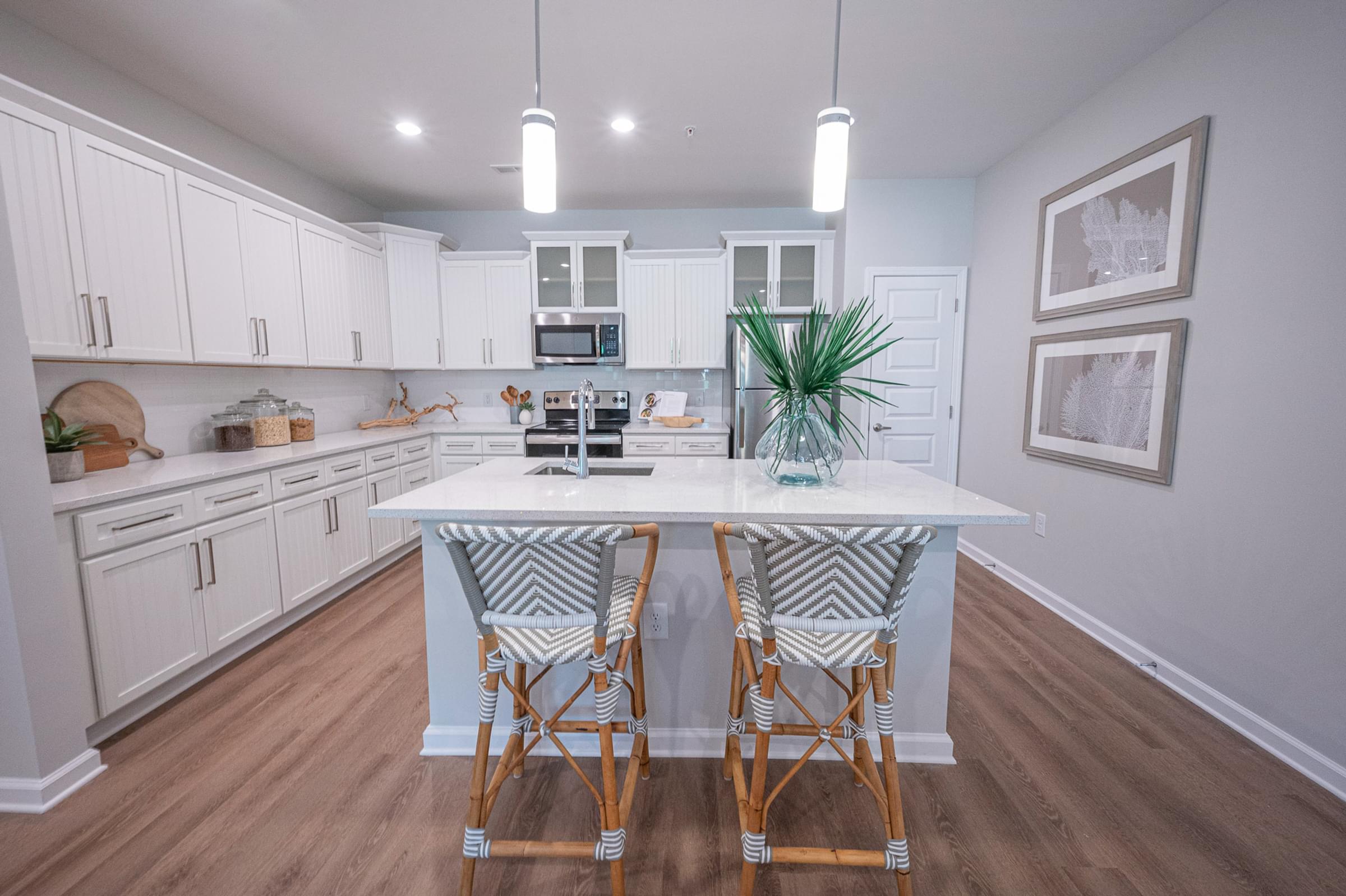 a kitchen with white cabinets and an island with bar stools