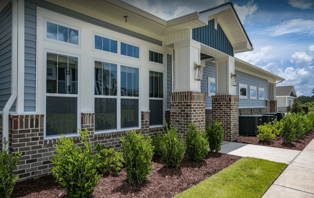 a home with a sidewalk and landscaping in front of it