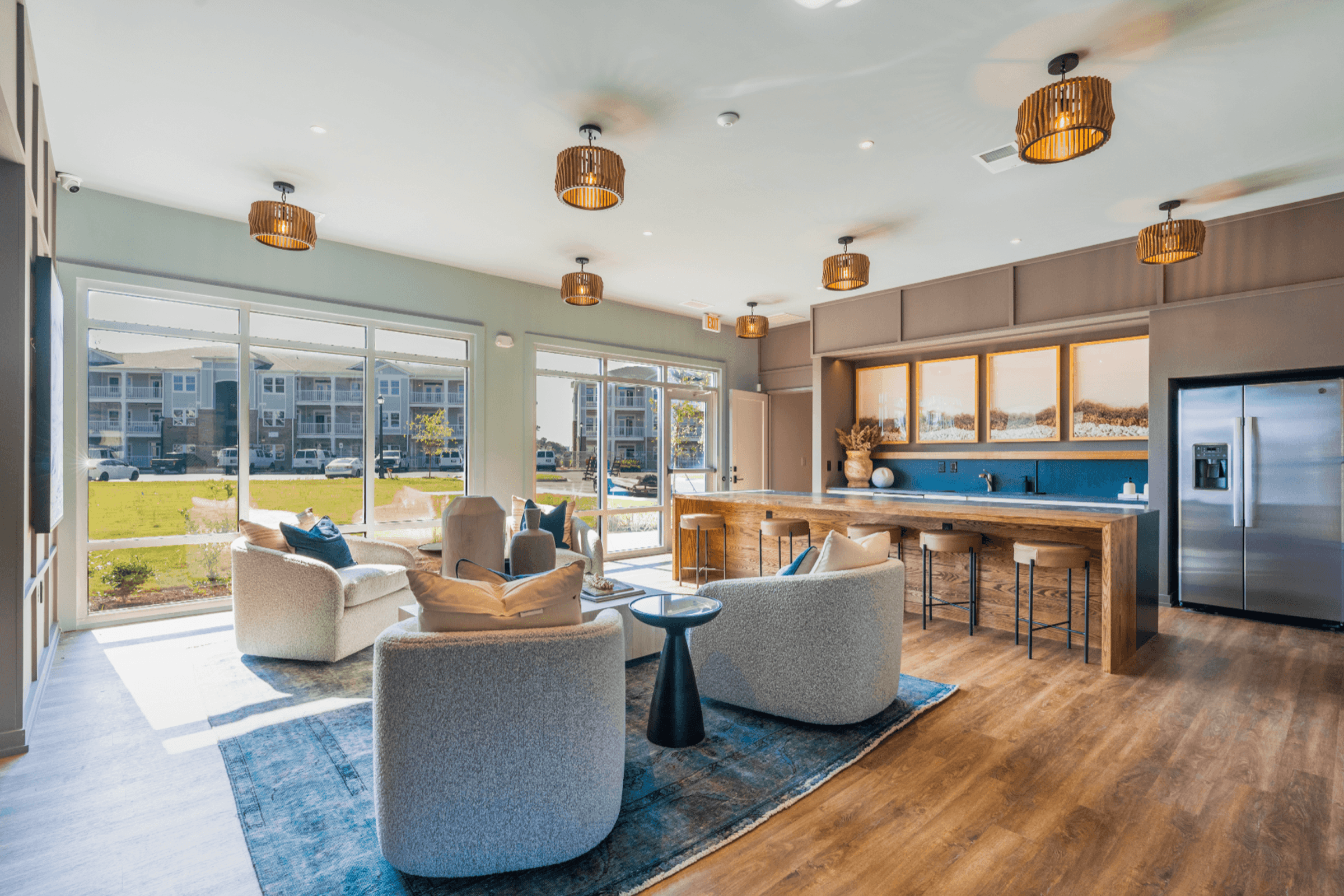 a living room with couches and chairs and a kitchen