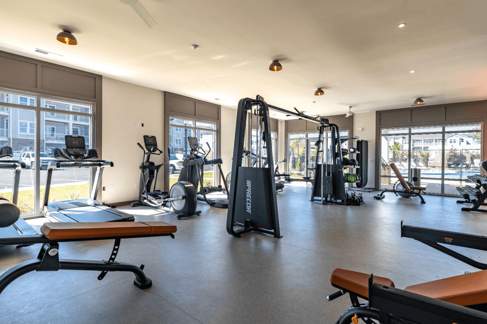 a gym with exercise equipment and windows in a building