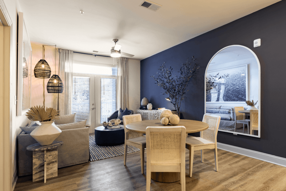 a living room with a blue accent wall and a dining room table