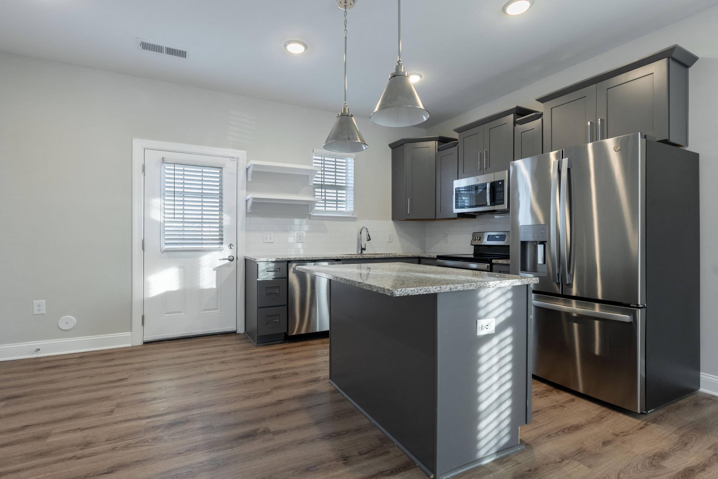 a kitchen with stainless steel appliances and a island in the middle