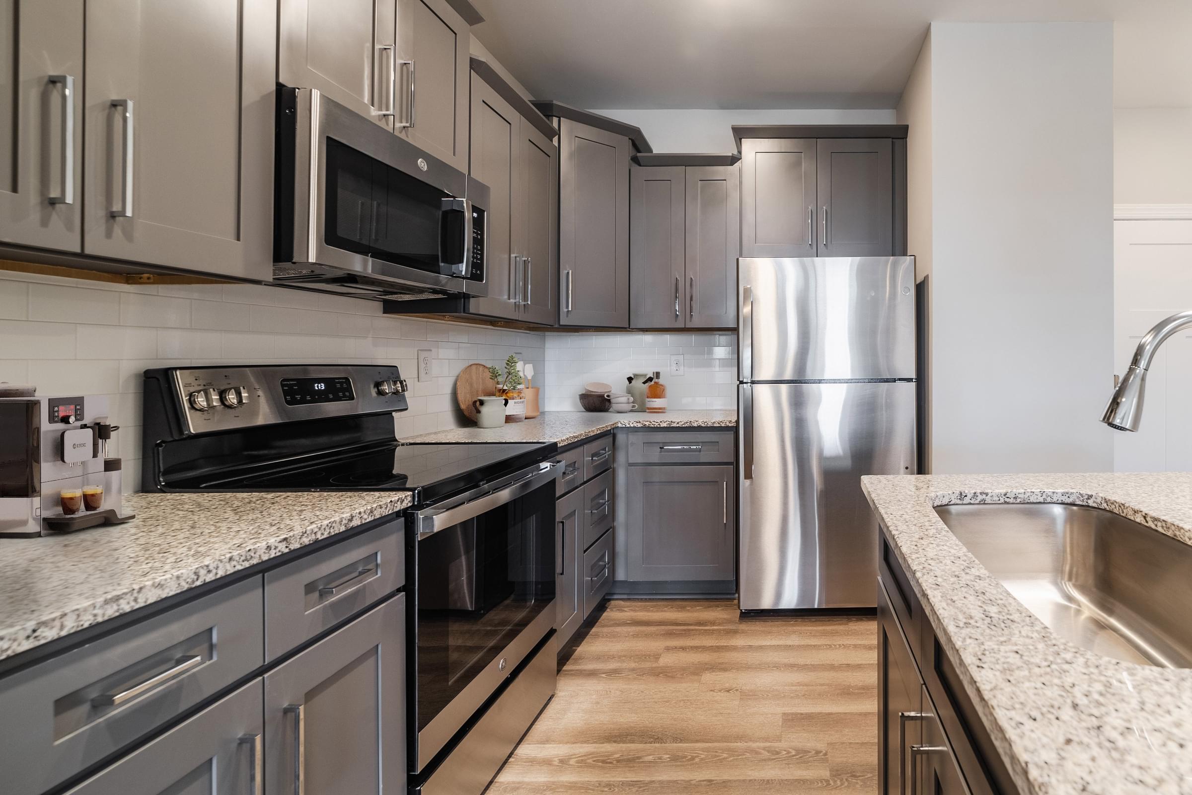 an updated kitchen with stainless steel appliances and granite counter tops