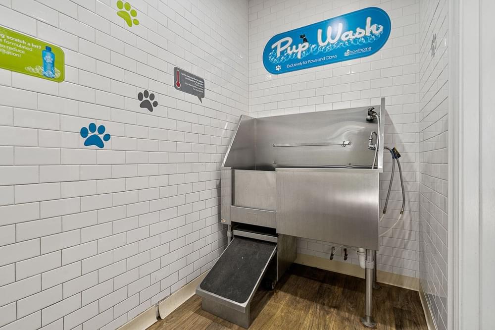 a tiled wall with a stainless steel pet wash station