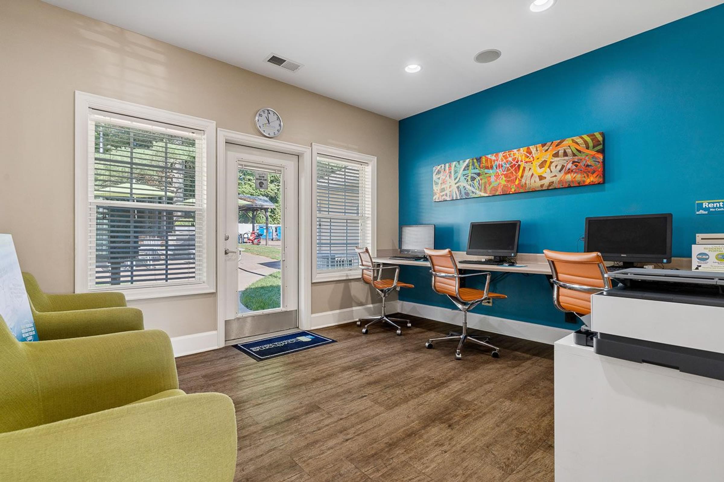a office with a desk and chairs and a clock on the wall