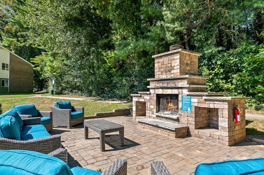 a patio with furniture and a stone fireplace