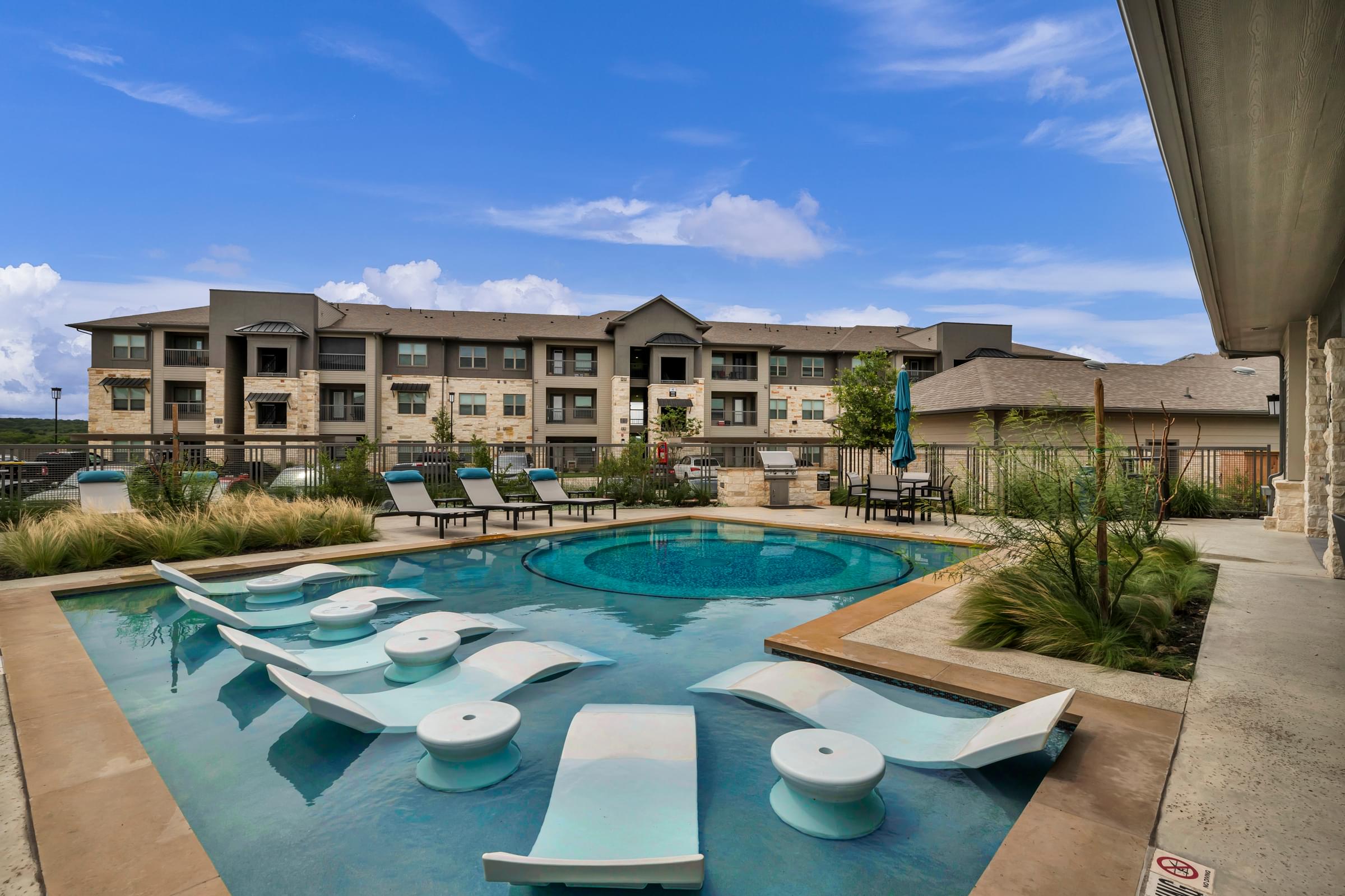 Resort Style Pool with Water Lounger Chairs