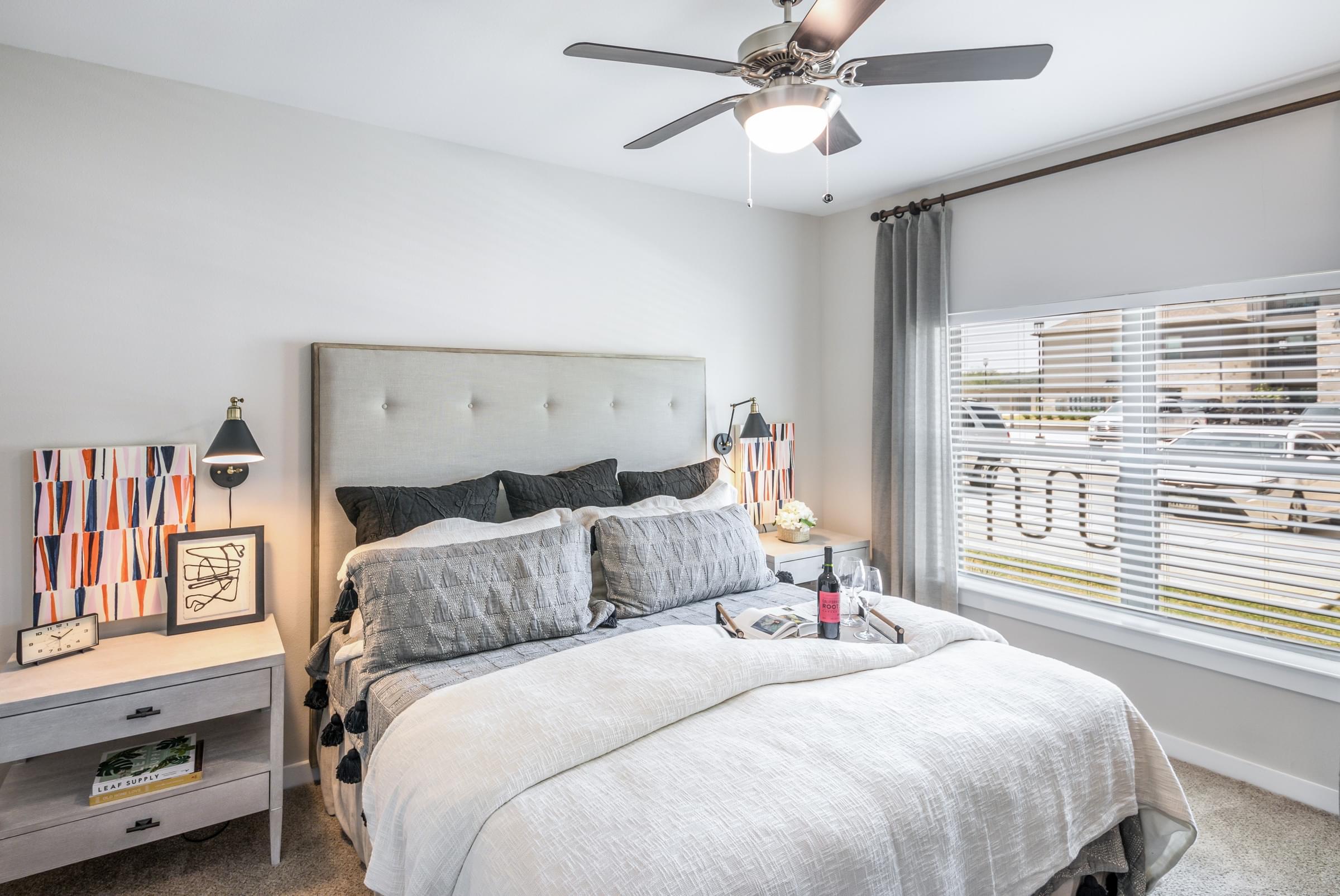 a bedroom with a large bed and a ceiling fan