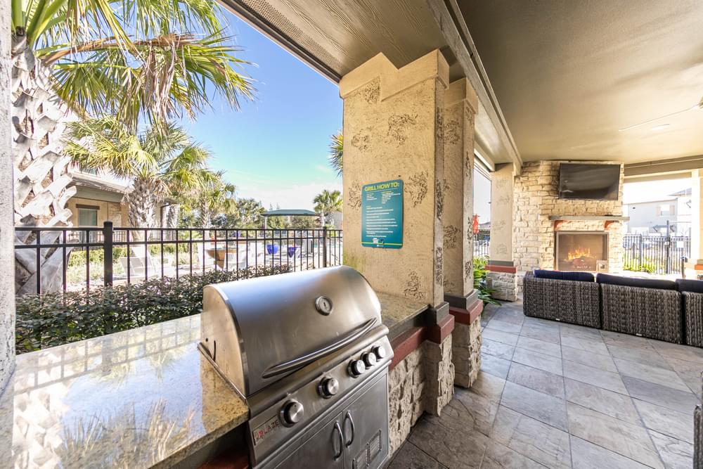 a patio with a grill and a fireplace