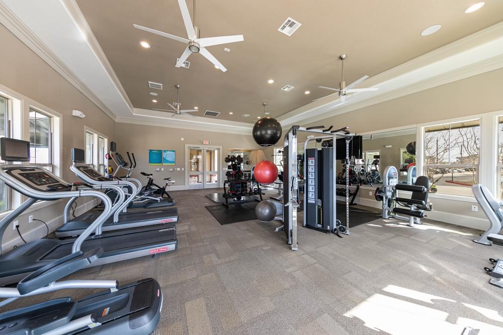 a gym with treadmills and other equipment at the enclave at woodbridge apartments