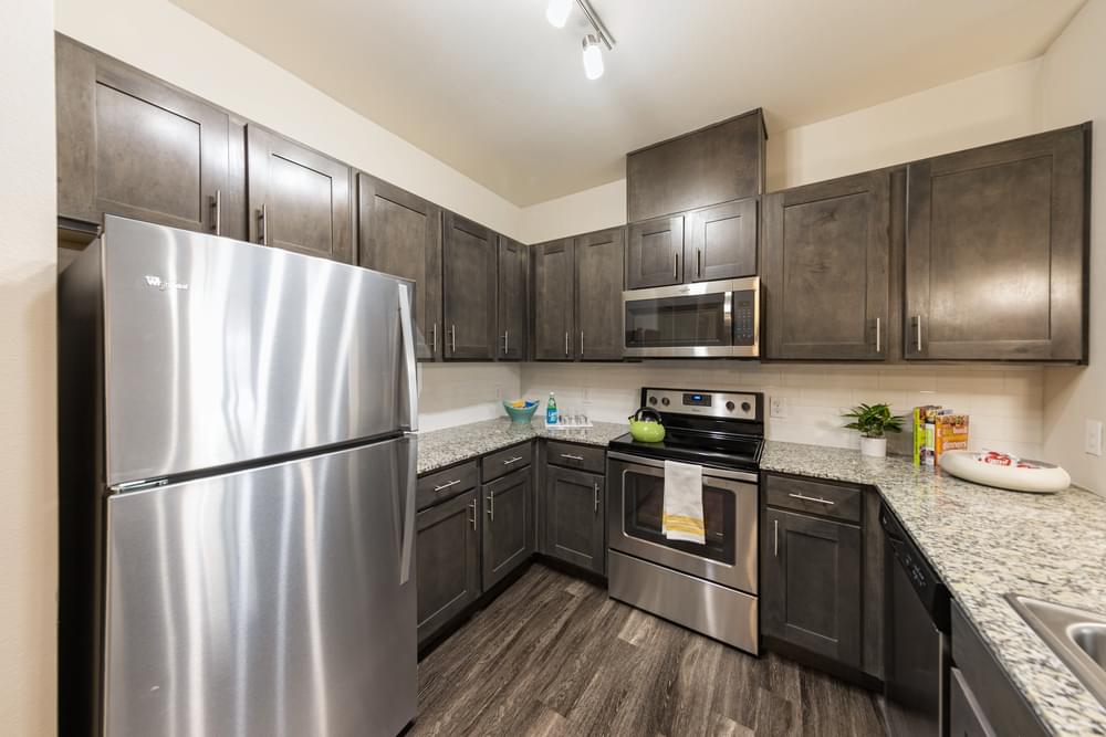redesigned kitchen with stainless steel appliances and granite counter tops and dark wood cabinets